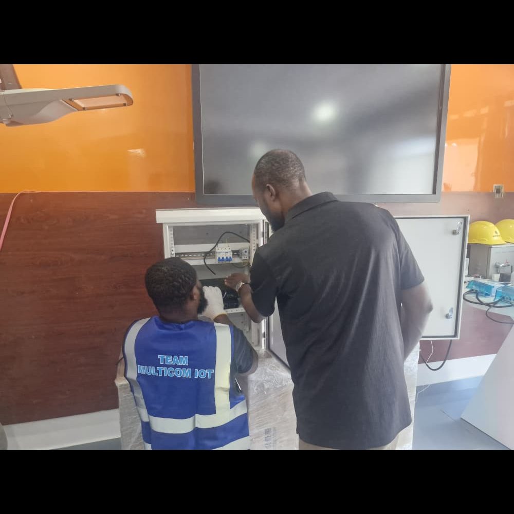 MulticomIoT engineers wiring a control cabinet on the bench